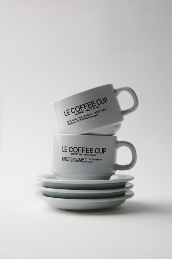 Stacked ceramic coffee cup mockups with matching saucers on light background