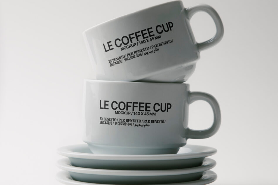 Two ceramic mugs with Le Coffee Cup text stacked on matching saucers