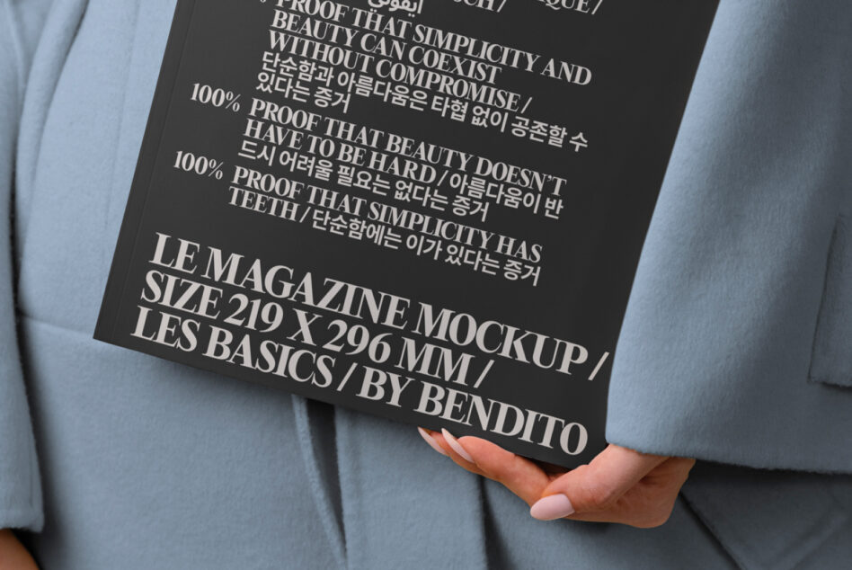 Magazine mockup on blue fabric, held by hand with manicured nails