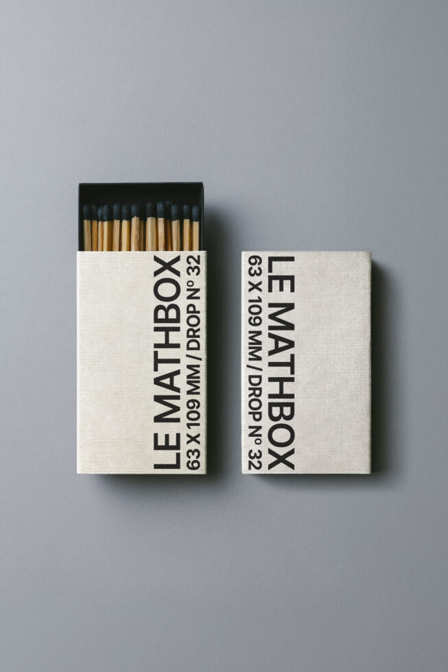 Off white matchbox with black text showing specs, dark blue match tips inside