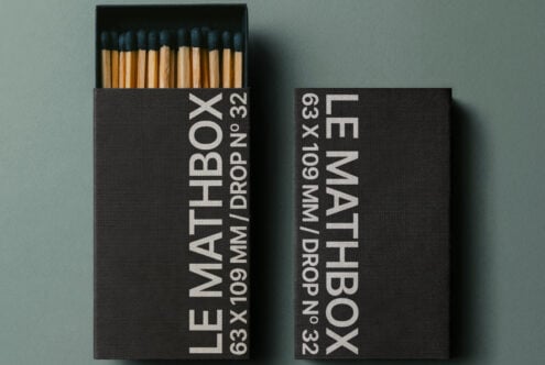 Black matchbox with white text showing specs, dark blue match tips visible inside