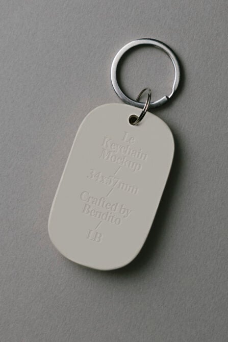 Cream keychain tag with embossed text on gray background
