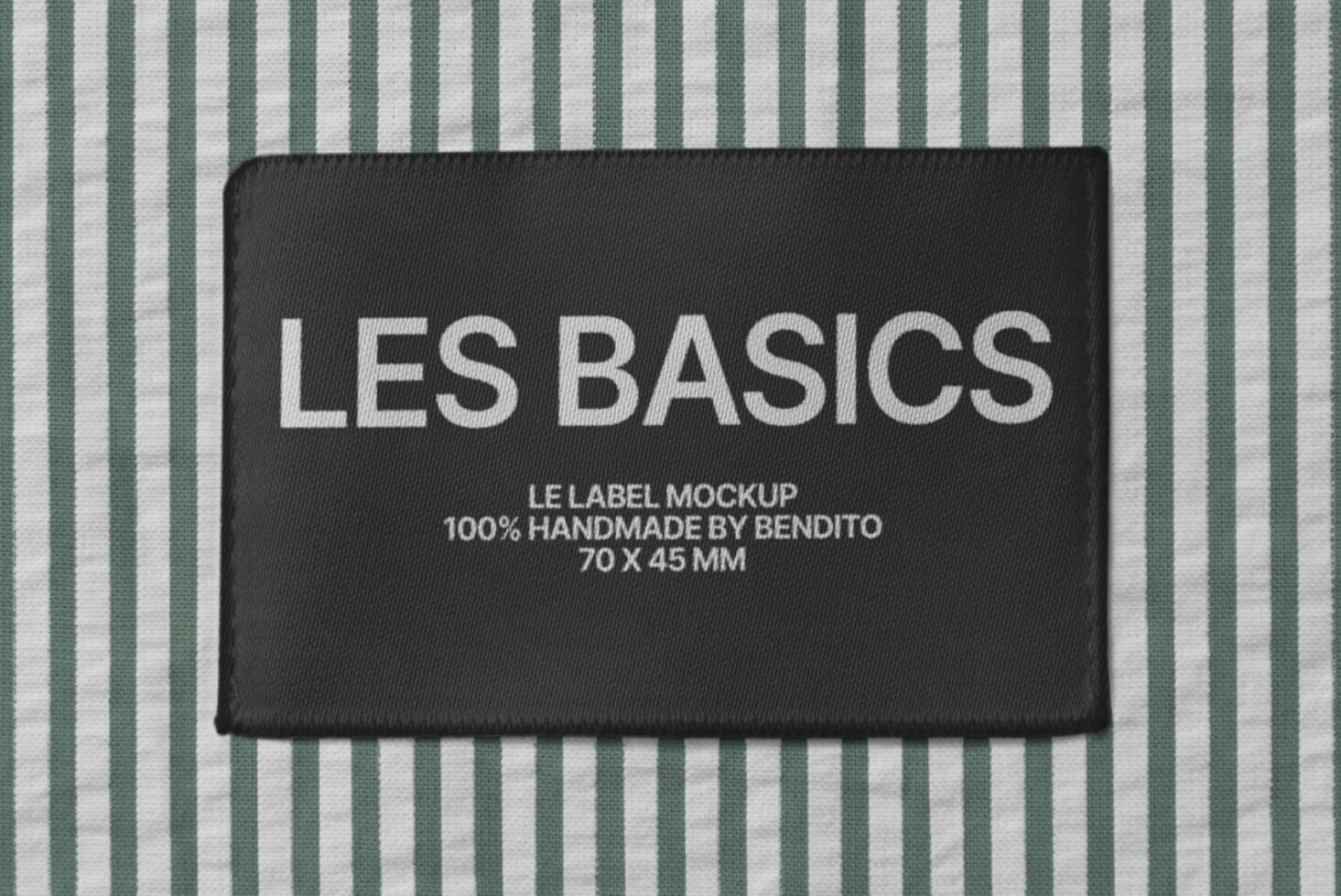 Black woven label on green striped fabric with Les Basics branding