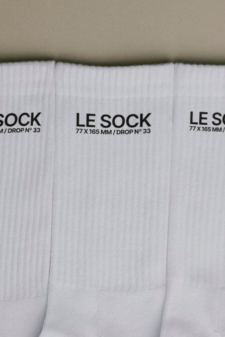 Stack of white ribbed socks with black Le Sock label showing 77 x 165 mm drop number 33