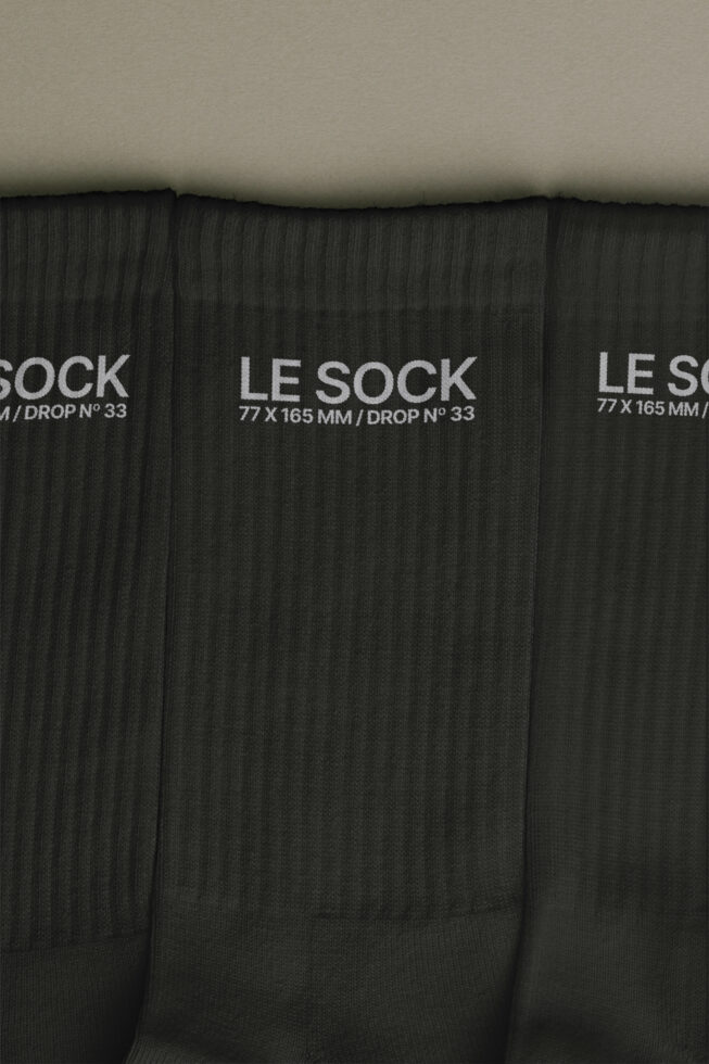 Stack of black ribbed socks with white Le Sock label showing 77 x 165 mm drop number 33