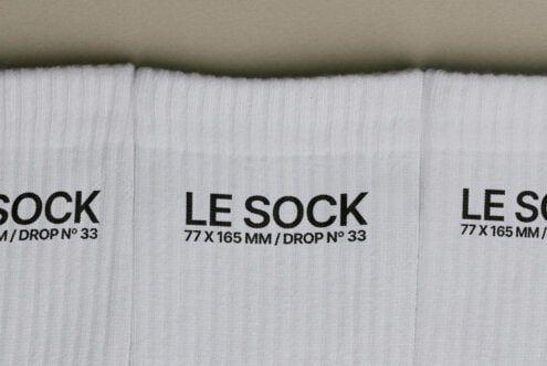 Overhead shot of white ribbed socks with black Le Sock label, drop number 33 visible