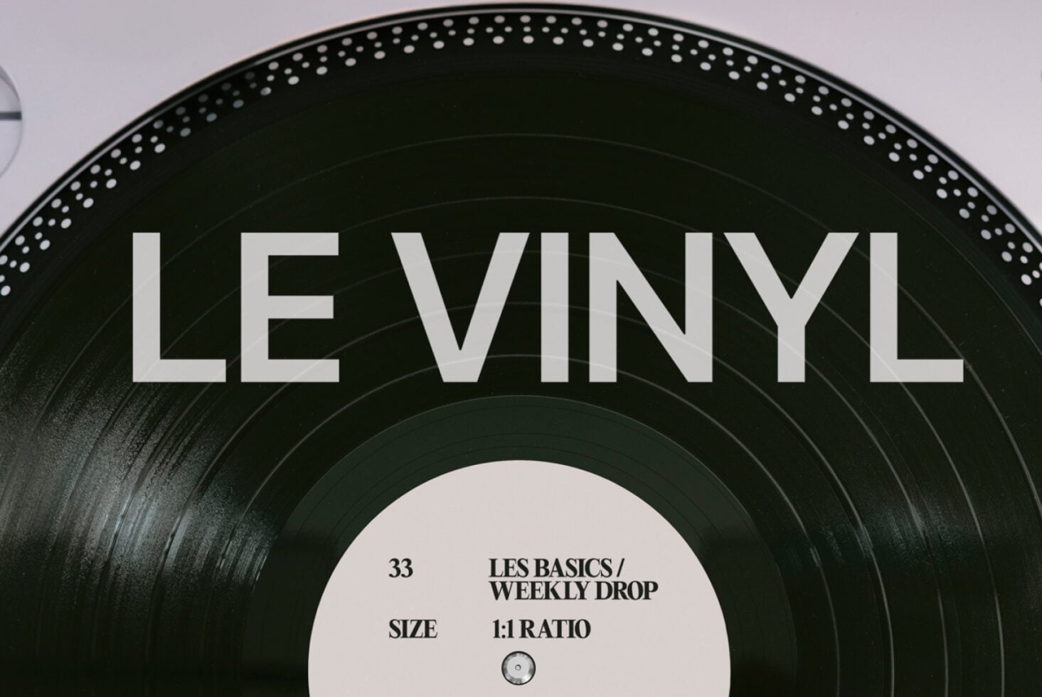 Black vinyl record with white center label featuring Les Basics Weekly Drop details
