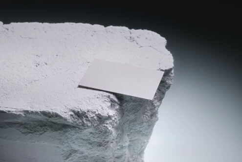 Blank business card mockup on white cliff edge against dark sky