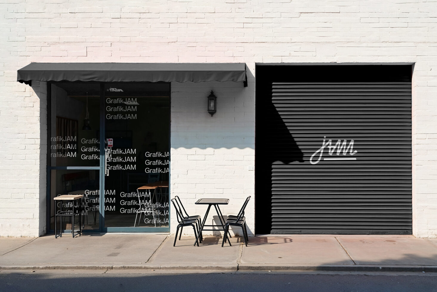 Dark storefront gray awning, metallic shutter, outdoor seating display