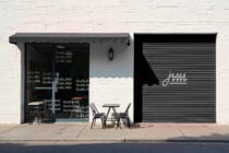 Dark storefront gray awning, metallic shutter, outdoor seating display