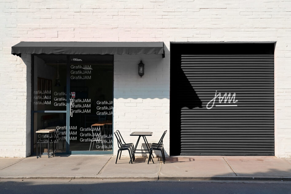 Dark storefront gray awning, metallic shutter, outdoor seating display