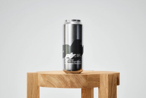 Labeled metallic can mockup on wood block showing black design label wrap