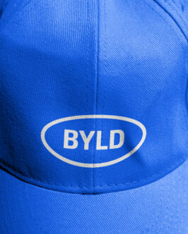 Blue baseball cap with BYLD logo in oval patch on front