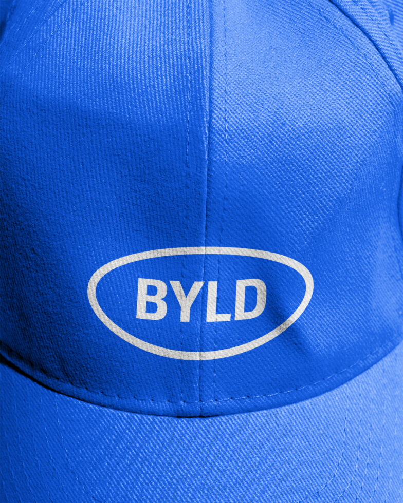 Blue baseball cap with BYLD logo in oval patch on front