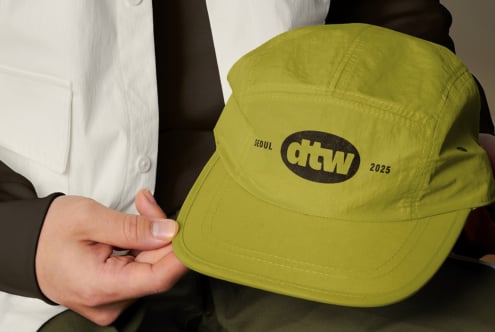 Close up of lime green snapback cap showing dtw logo detail on fabric