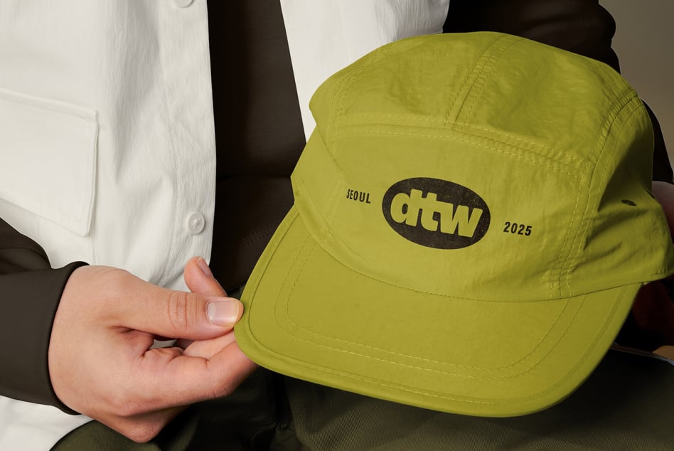 Close up of lime green snapback cap showing dtw logo detail on fabric