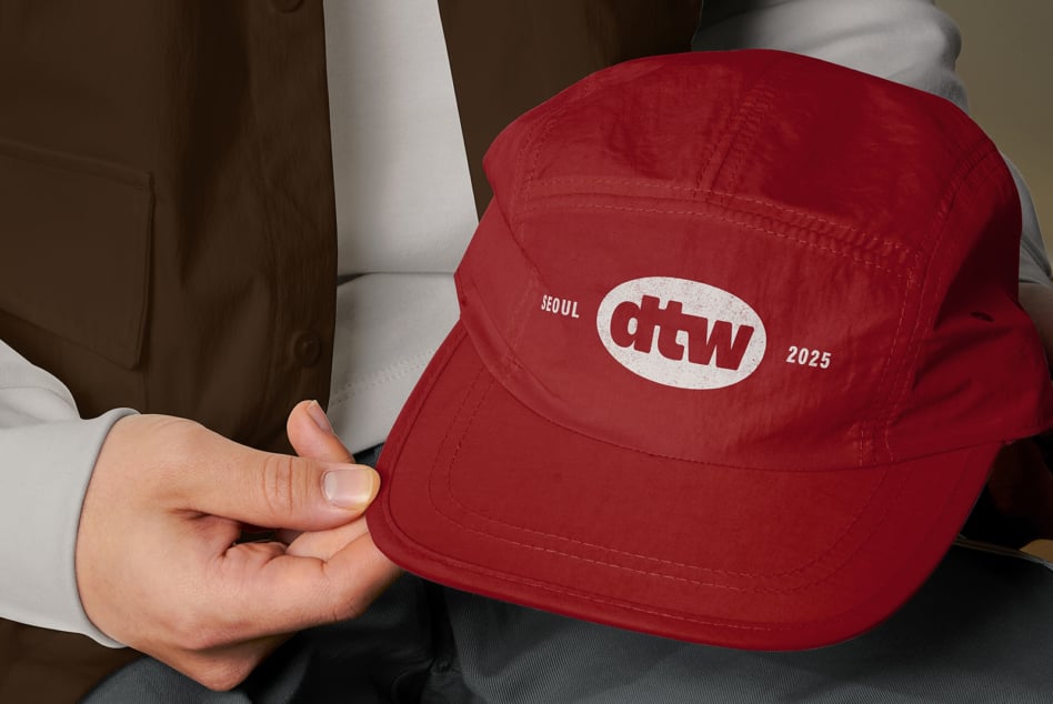 Red baseball cap with Seoul, ROMA logo worn by person in white shirt