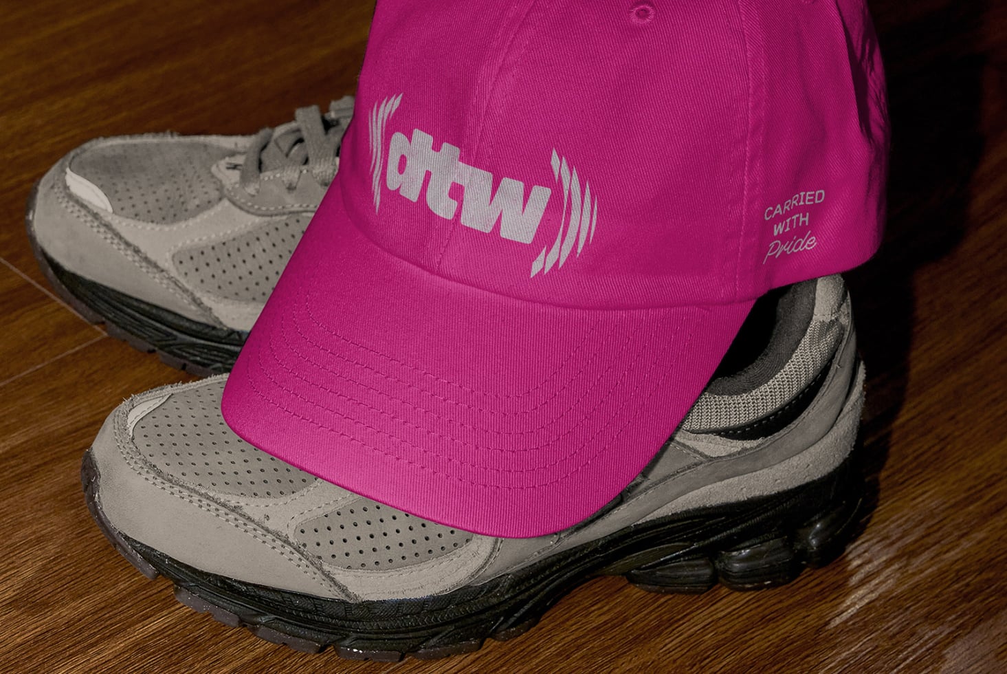 Magenta cap with ohtwn logo worn over tan outdoor hiking shoe