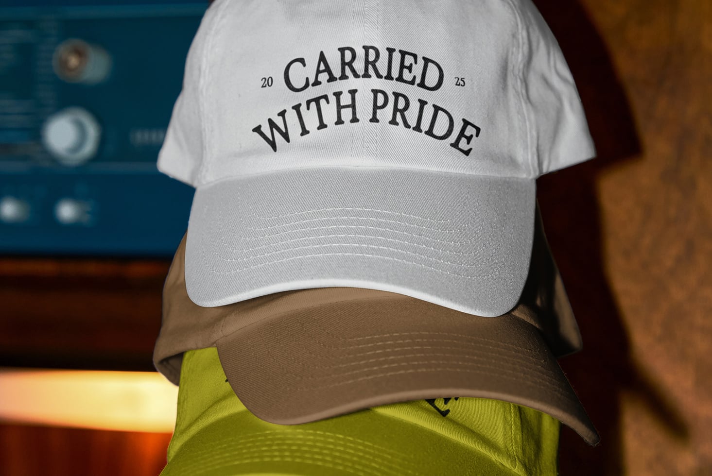 White cap brown brim with Carried With Pride over neon jacket