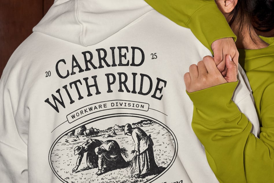 Cream hoodie showing Carried with Pride design with workwear division engraving