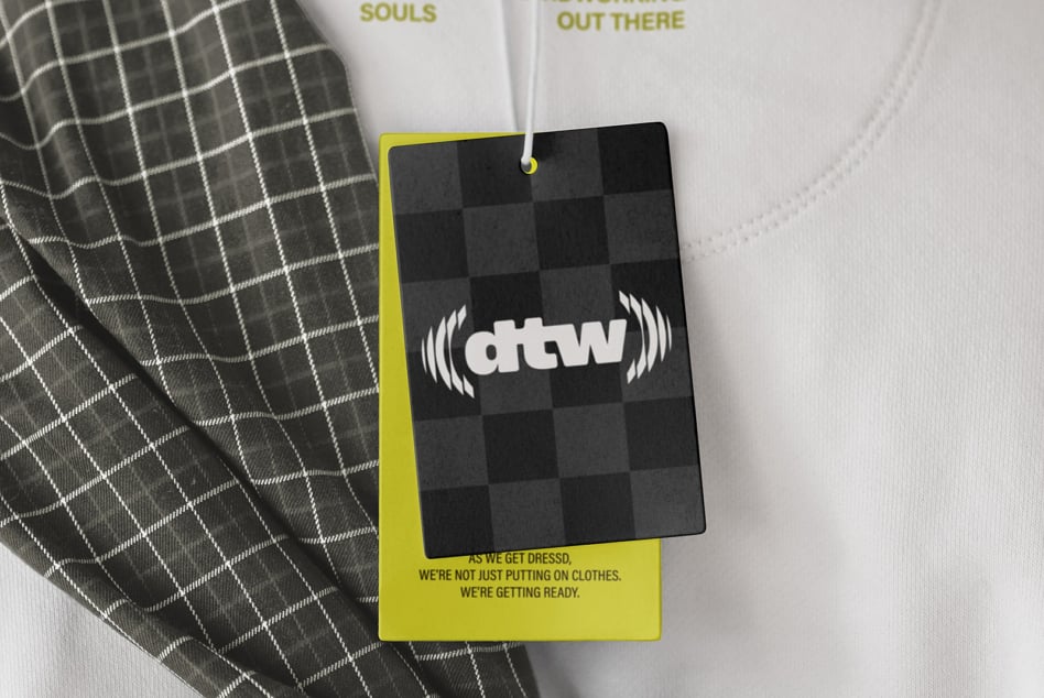 Hanging ID badge mockup with yellow border, checkered black design on charcoal cardigan
