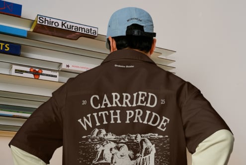 Brown shirt back showing carried with pride graphic, light blue workwear cap