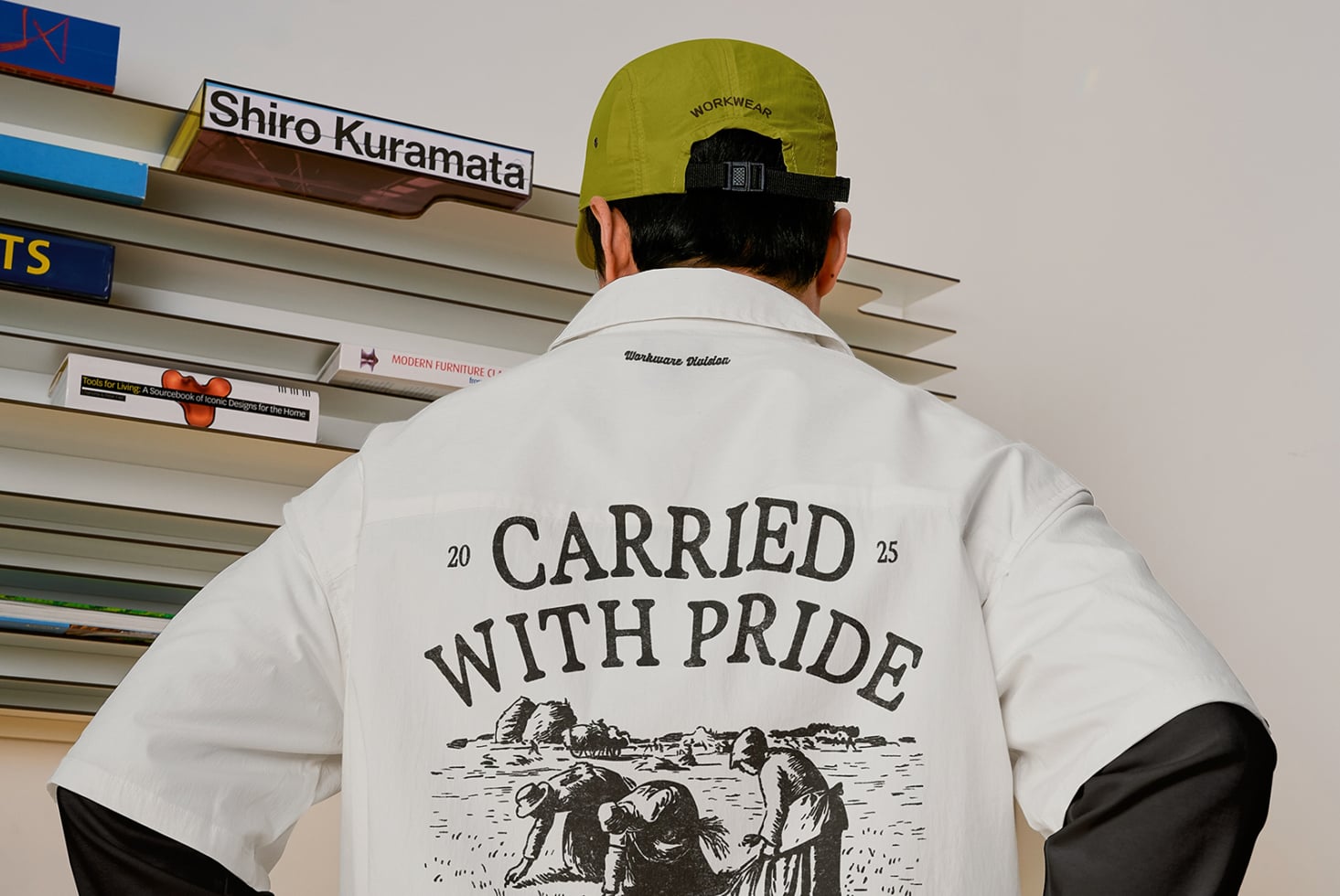 White shirt back with carried with pride design, neon cap at urban location