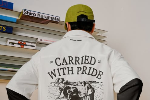 White shirt back with carried with pride design, neon cap at urban location