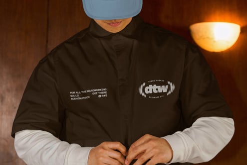 Sky blue camp cap worn with black coach jacket over white long sleeves