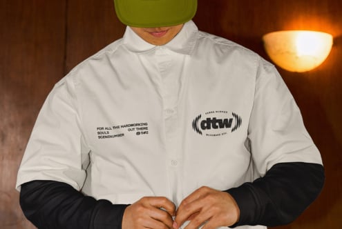 White button-up shirt with printed text reading 'For all the hardworking souls out there' worn with lime green cap