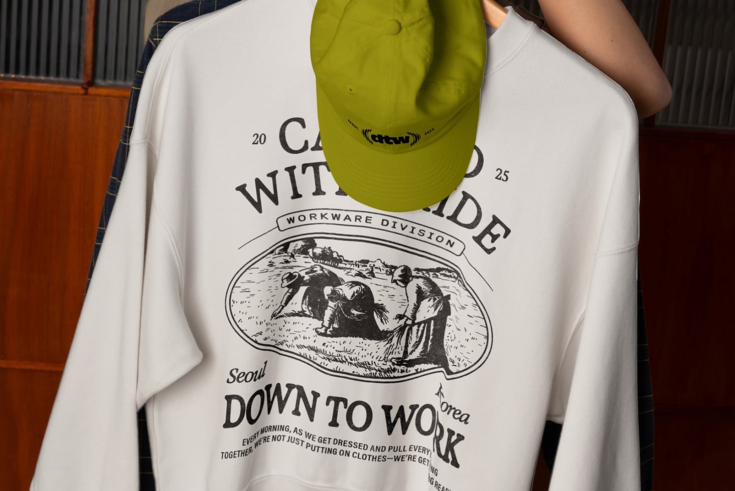 Lime camp cap mockup hanging from light blue sweatshirt with back print