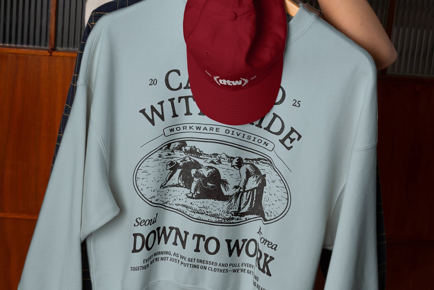 Burgundy camp cap mockup displayed above light blue crewneck sweatshirt