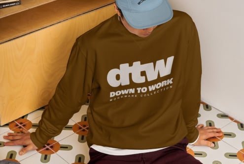 Overhead shot of person wearing olive sweatshirt with dtw logo on patterned floor