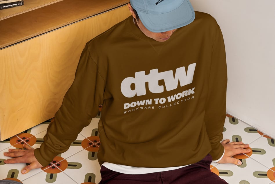 Overhead shot of person wearing olive sweatshirt with dtw logo on patterned floor