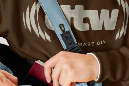 Close-up of light blue strap detail against brown fabric with large cream text design