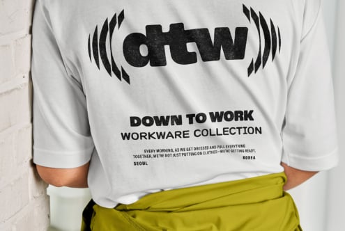 White crewneck sweatshirt with Down to Work Seoul graphic, worn with lime green pants