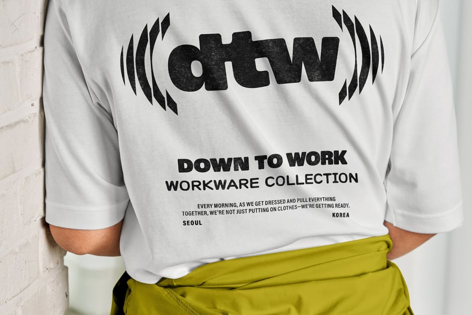 White crewneck sweatshirt with Down to Work Seoul graphic, worn with lime green pants