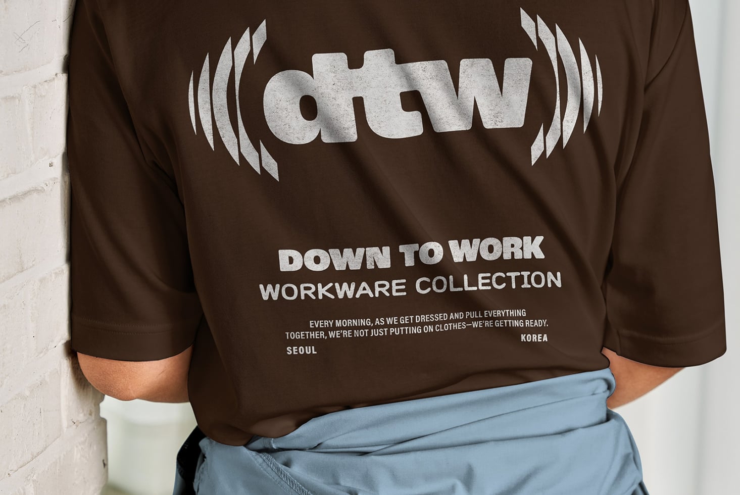 Back view of brown sweatshirt with dtw logo, down to work text, light blue pants
