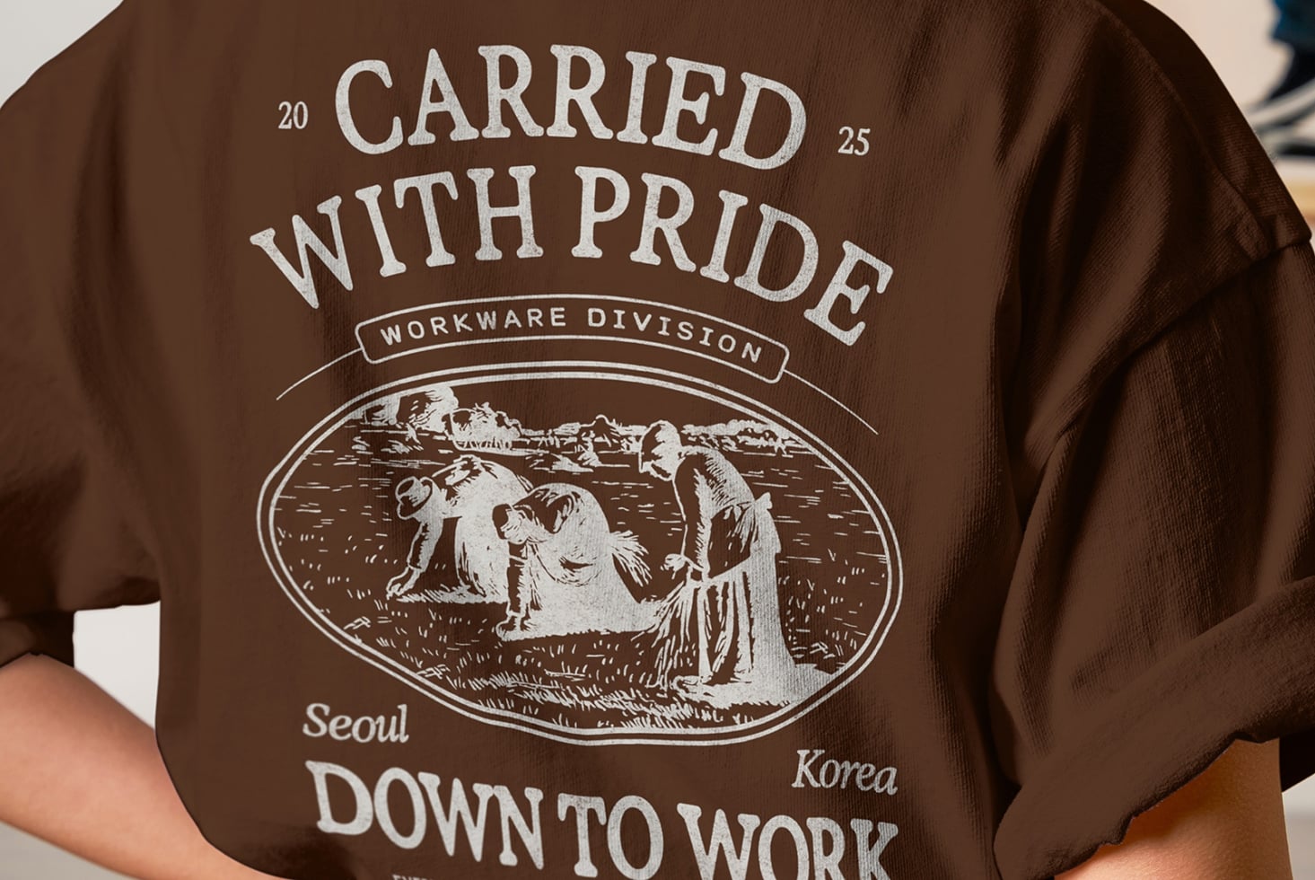 Close up of brown tee back showing Carried With Pride vintage workwear print