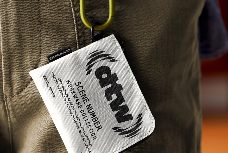 White fabric tag with yellow carabiner clip on tweed fabric background