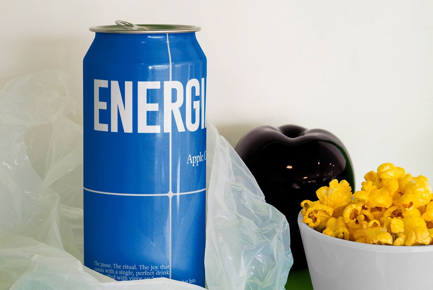 Blue ENERGIA can next to popcorn in bowl with movie still in shot