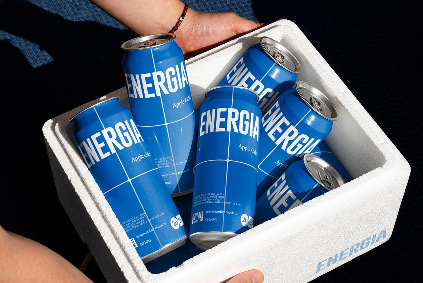 White foam cooler packed with blue ENERGIA cans being held overhead