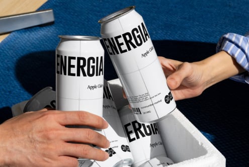 Two people toasting white ENERGIA cans on blue textured surface