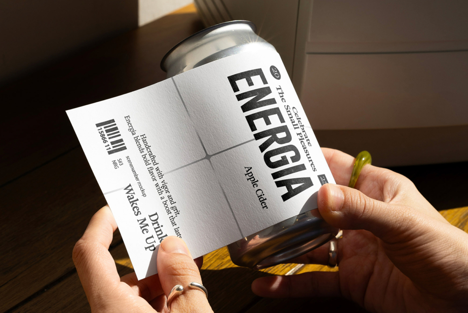 Hands gripping white energy can label mockup on wooden surface indoors