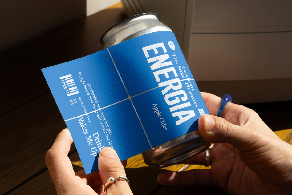 Hands holding blue energy drink can with unfolded label mockup sheet