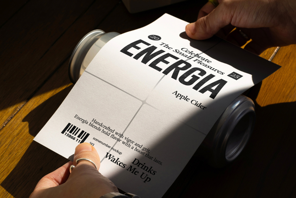 White can label mockup sheet held in hands with beverage can visible