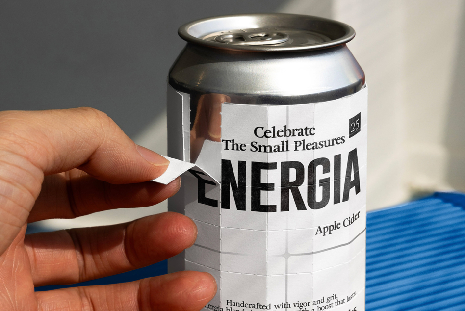 White Energia apple cider can with metallic top in hand against blue