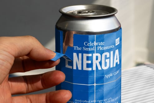 Hand holding blue Energia apple cider can with pull tab visible