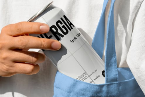 Hand holding white Energia can with blue fabric in background