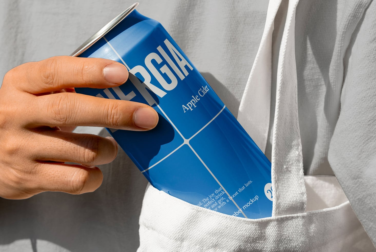 Blue Energia apple cider can being pulled from white cloth pocket